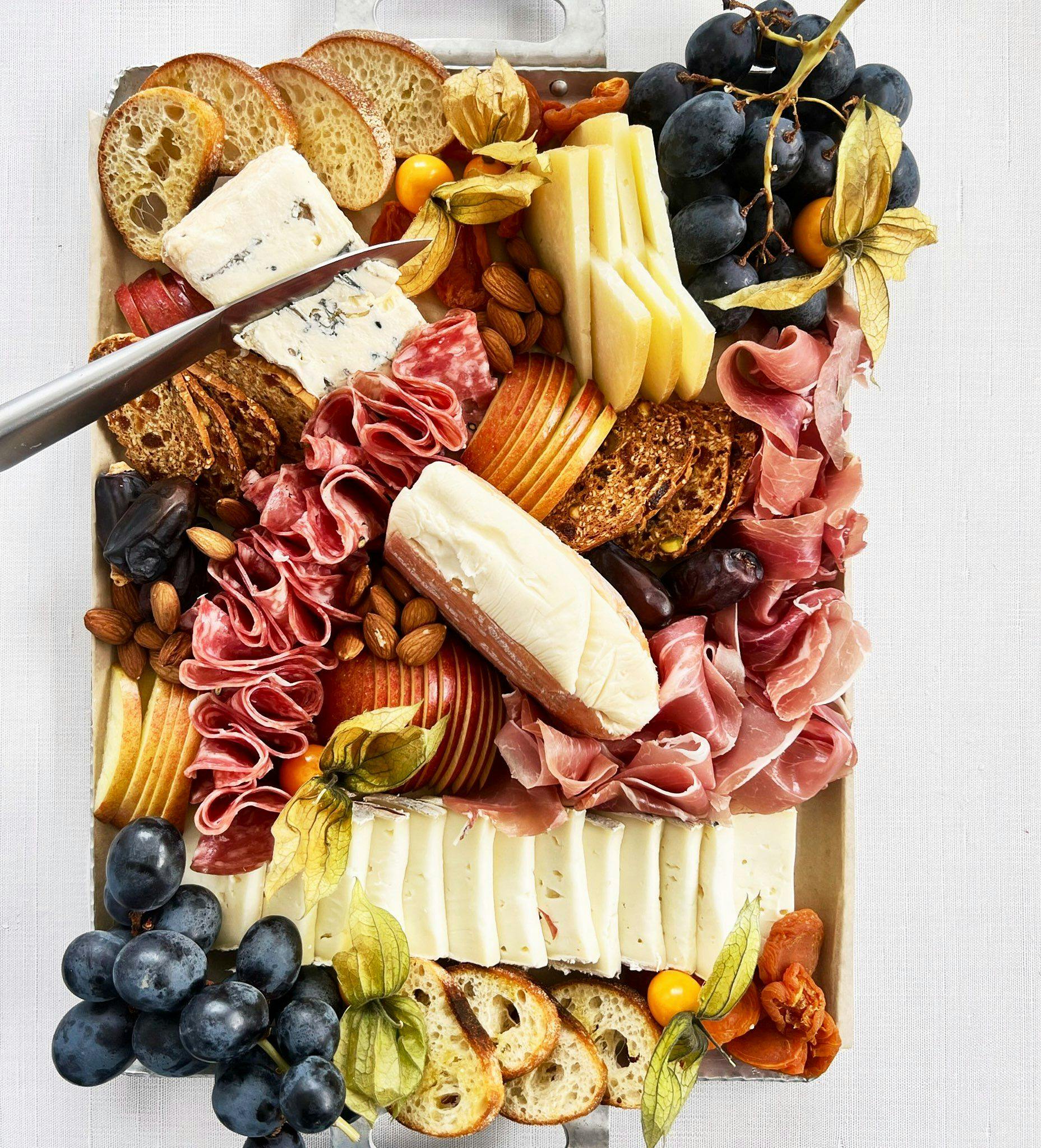 Charcuterie Board with meats, cheeses, grapes, toasts