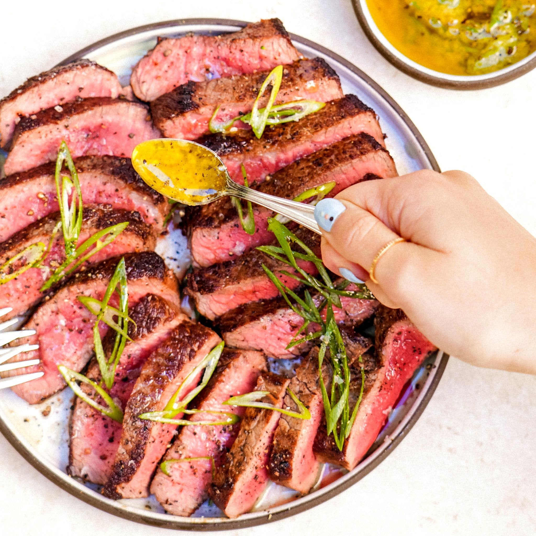 Sliced Sirloin Steak with Roasted Garlic Sauce, Sliced Scallions & Cracked Pepper